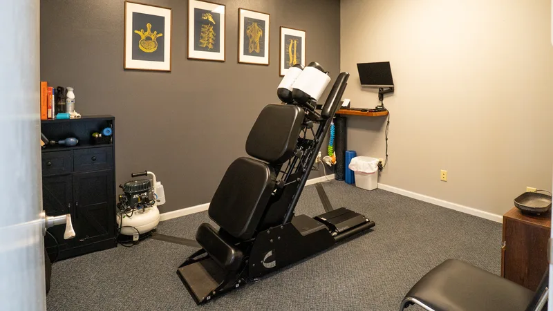 Chiropractic treatment room with adjustment table and therapy equipment