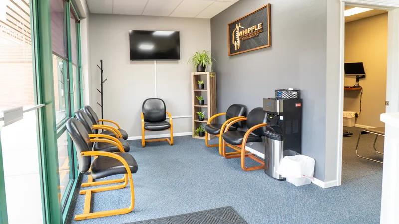 Whipple Chiropractic waiting area with green curtains and black chairs